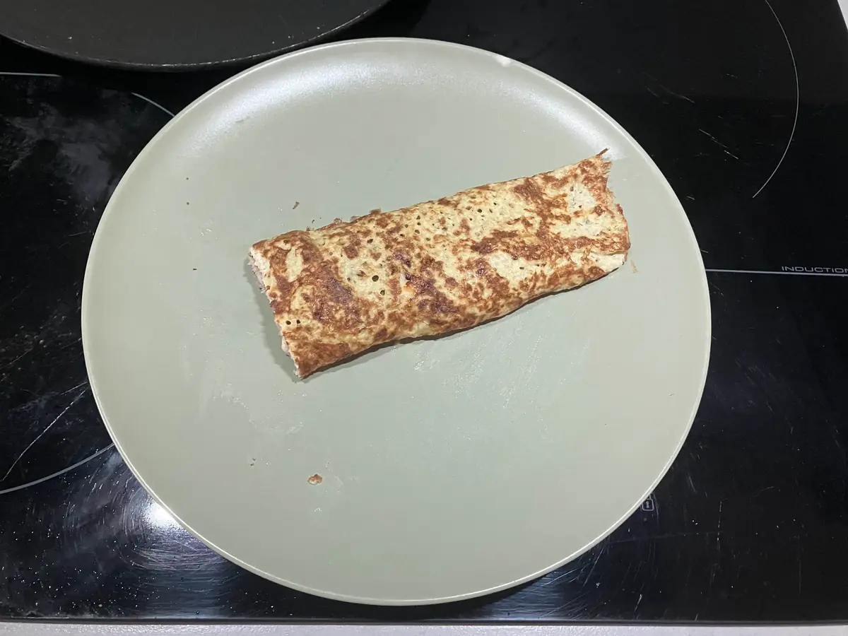 Crêpe low carb roulée garnie de fromage à raclette fondu et jambon grillé